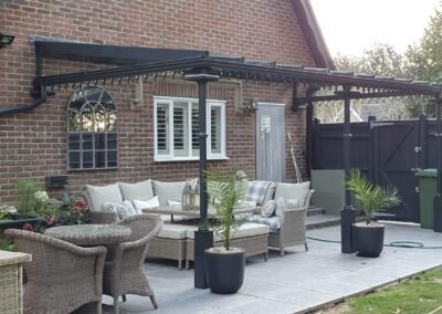 Black steel veranda lean-to system covering grey patio